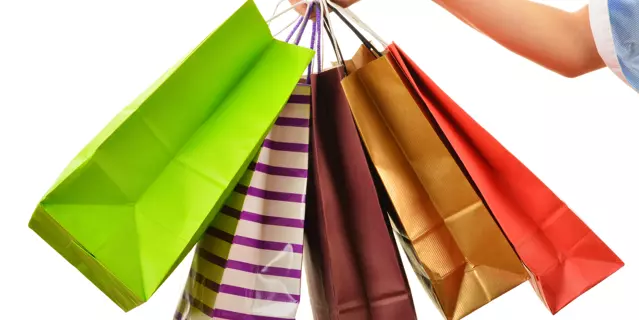Female hand holding paper shopping bags isolated on white background
