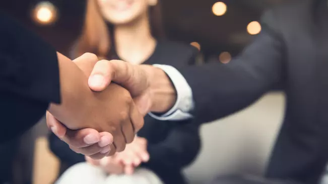 Businessmen making handshake with his partner in cafe - business etiquette, congratulation, merger and acquisition concepts