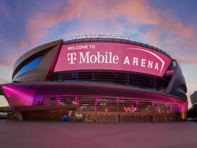 Exterior shows the T-Mobile Arena lit up at night with pink lights.