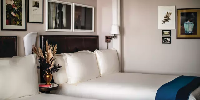 White room at The Reserve at Park MGM with a queen-sized bed and decorated with art in wall frames.