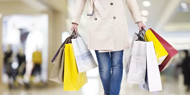 woman with colorful shopping bags walking in modern mall.