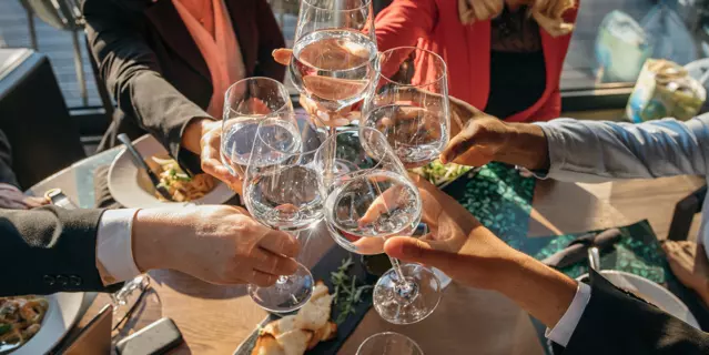 Group of business people toasting for success that they achieved on a business meeting in restaurant.