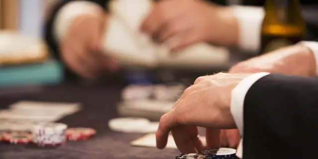 Playing poker at table gambling with chips and cards 2 people