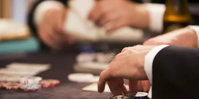 Playing poker at table gambling with chips and cards 2 people