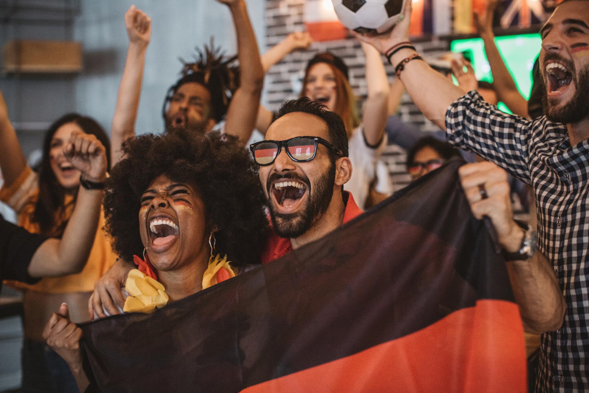 Soccer fans cheering for German team in pub.