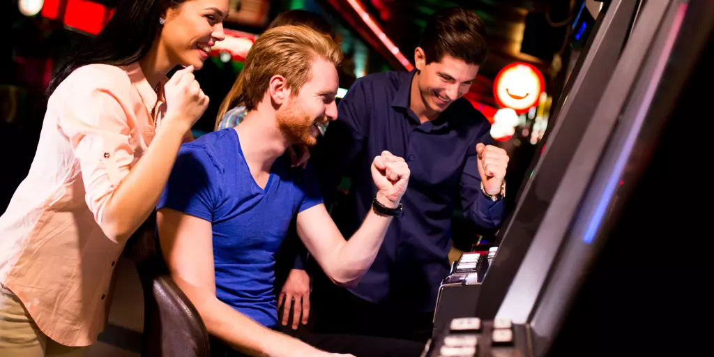 Young people at slot machine in the casino