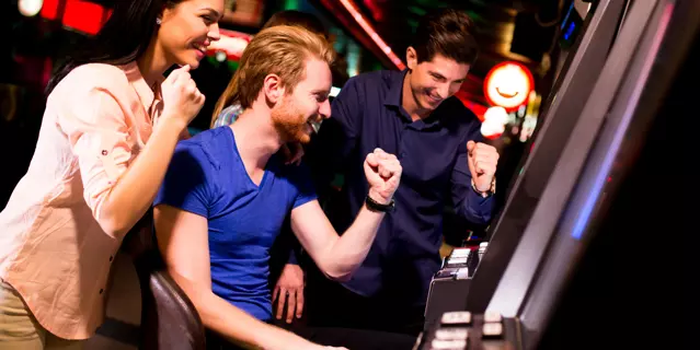 Young people at slot machine in the casino