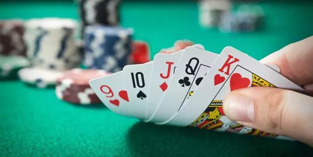 Man plays poker in the casino. Holding cards in hand, gambling concept