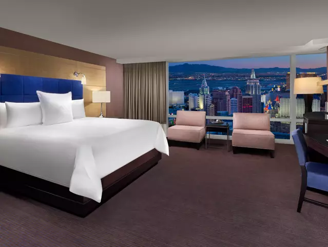 ARIA hotel bedroom with a large bed dressed in crisp white linens and a window overlooking the Las Vegas skyline.