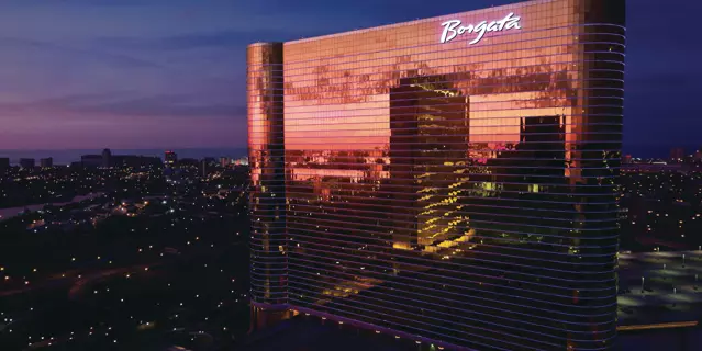 Exterior of Borgata at night shows the city lights reflected in the 41 floors.