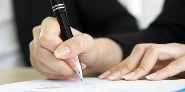 Business woman signing the contract to conclude a deal.