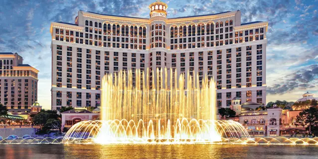 Exterior shows Bellagio resort with a lake and large water foundation in front.
