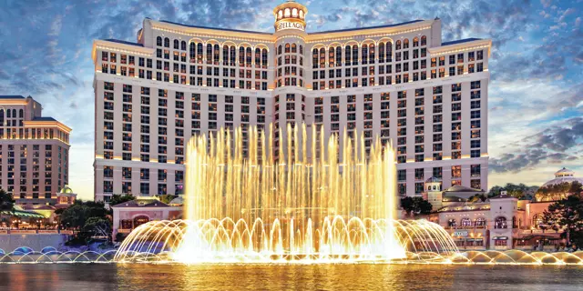 Exterior shows Bellagio resort with a lake and large water foundation in front.