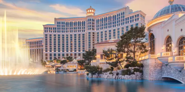 Exterior of the Bellagio with 14 floors and more than 400 windows on a waterfront with fountains.