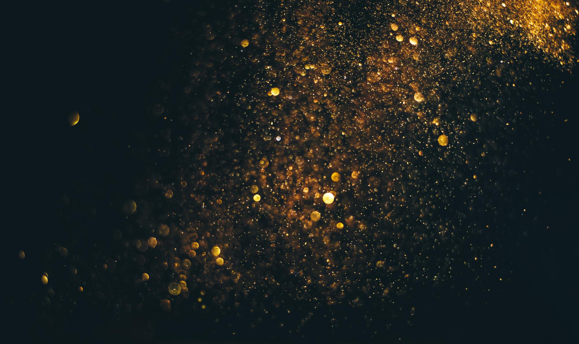 glitter vintage lights background. gold and black. de focused