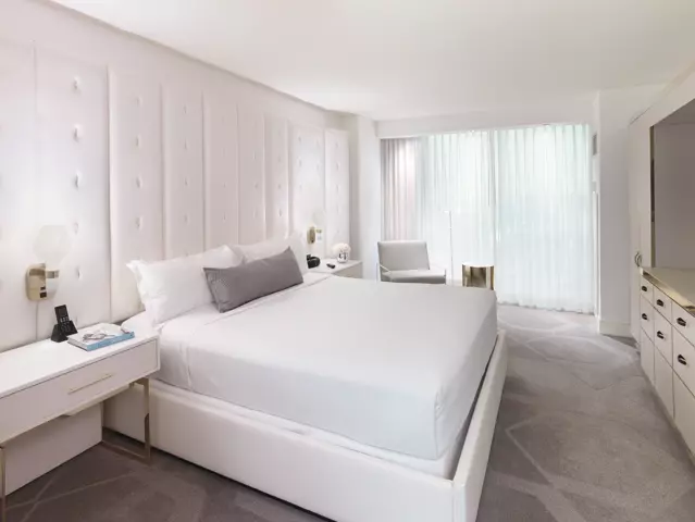W Las Vegas hotel bedroom with a large bed dressed in crisp white linens.
