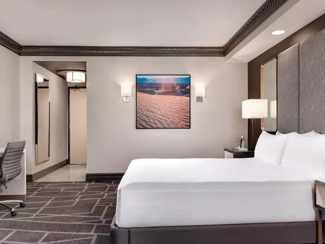 Luxor hotel bedroom with a large bed dressed in crisp white linens.