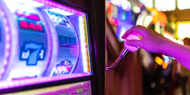 Gambling Theme. One Handed Bandit Slot Machine Bid and Spin in Las Vegas Casino. Caucasian Woman Playing Game.