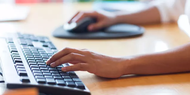 business, education, programming, people and technology concept - close up of african american female hands typing on keyboard and using mouse