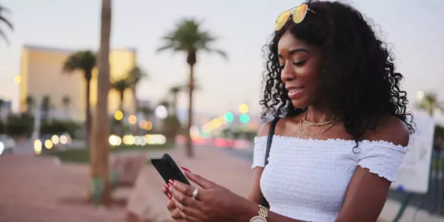african american woman using smartphone on las vegas streets