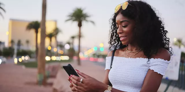 african american woman using smartphone on las vegas streets